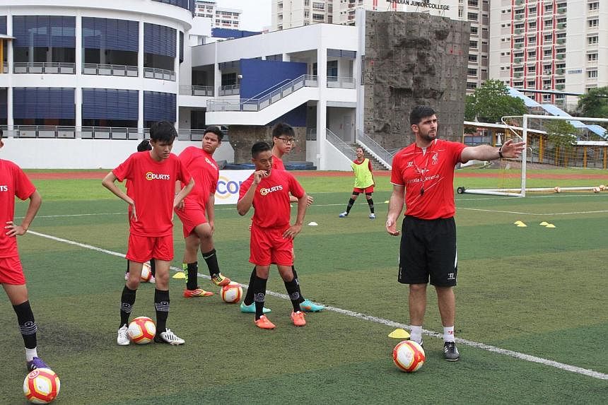 Anthony Owens (right), Coach for the Courts and Liverpool Football Academy 2014, and participants from the Sg Cerebral Palsy Football Team and Special Olympics Football Team. -- PHOTO: COURTS SINGAPORE