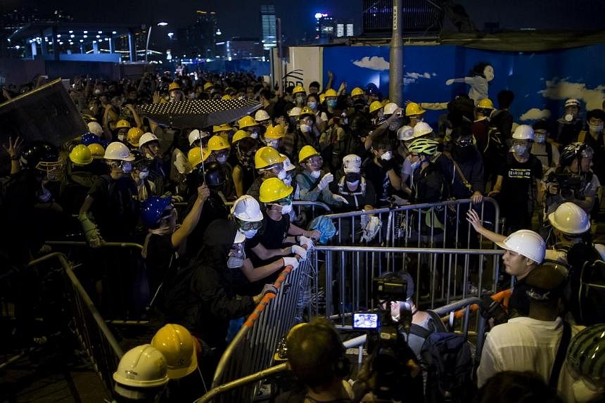 Pro-democracy protesters set up a new road block close to the chief executive office in Hong Kong Nov 30, 2014. Hundreds of Hong Kong pro-democracy activists scuffled with police on Sunday as they tried to encircle government headquarters, defying or