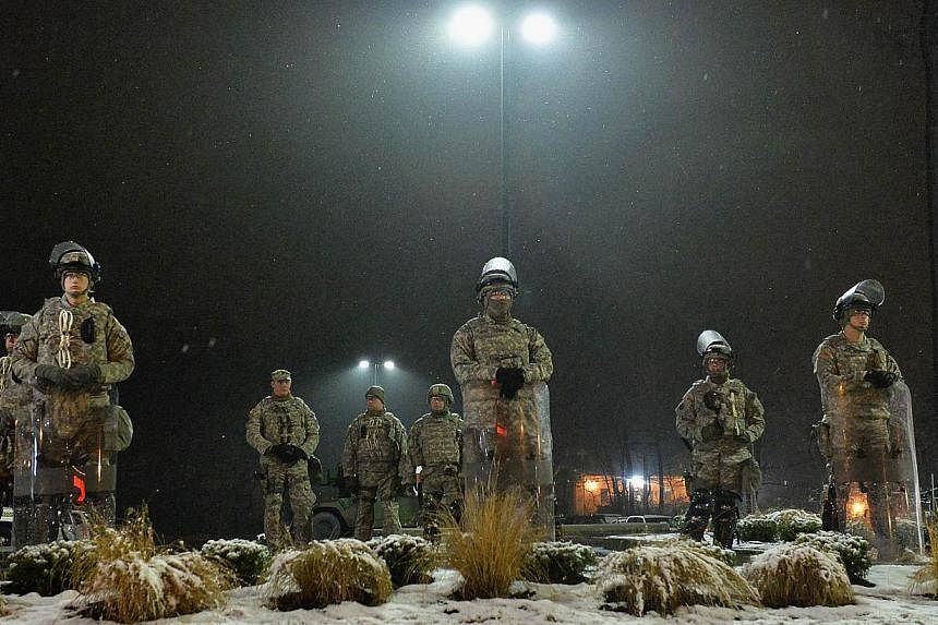 Members of the Missouri National Guard stand on patrol outside the Ferguson Police Department on Nov 26, 2014 in Ferguson, Missouri. -- PHOTO: AFP