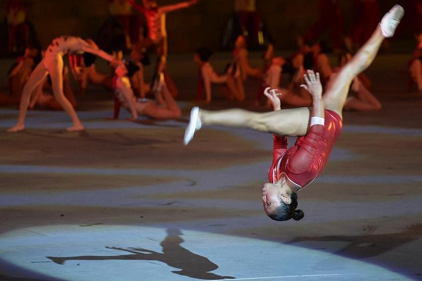 Seven gymnasts performed at the National Day Parade 2013, including Singapore’s first Olympic gymnast Lim Heem Wei (above) who wowed the audience with her somersaults across the parade stage.&nbsp;-- PHOTO: ST FILE