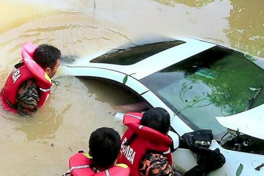 A fire and rescue team at the scene of an accident where a sports car veered off the road and plunged into a river. The driver was found dead at the scene. -- PHOTO: THE STAR/ASIA NEWS NETWORK