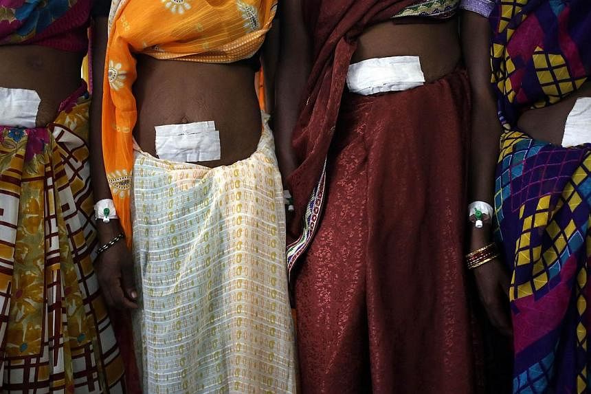 Women, who underwent sterilisation surgery at a government mass sterilisation camp, pose for pictures inside a hospital at Bilaspur district in the eastern Indian state of Chhattisgarh in this Nov 14, 2014 file photo. -- PHOTO: REUTERS