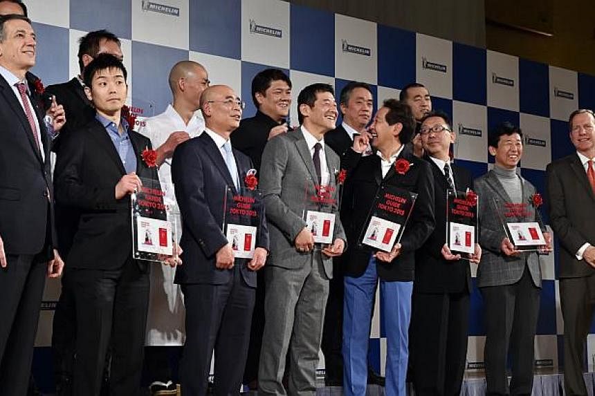 The heads of three-star restaurants selected by the new Michelin Guide Tokyo 2015 guidebook pose at a photo session during the publication announcement ceremony in Tokyo on Dec 02, 2014, along with Michelin Japan president Bernard Delmas (left) and M