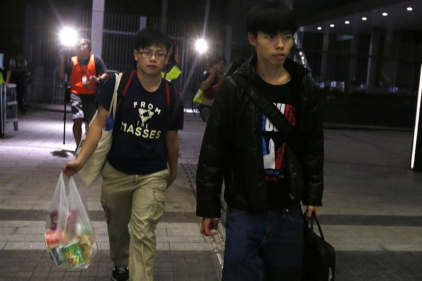 Student leader Joshua Wong (right) walks with a fellow student carrying cup noodles into the Legislative Council in Hong Kong on Sunday. Speaking on a stage on Monday night in the heart of the Admiralty protest site next to government headquarters, W