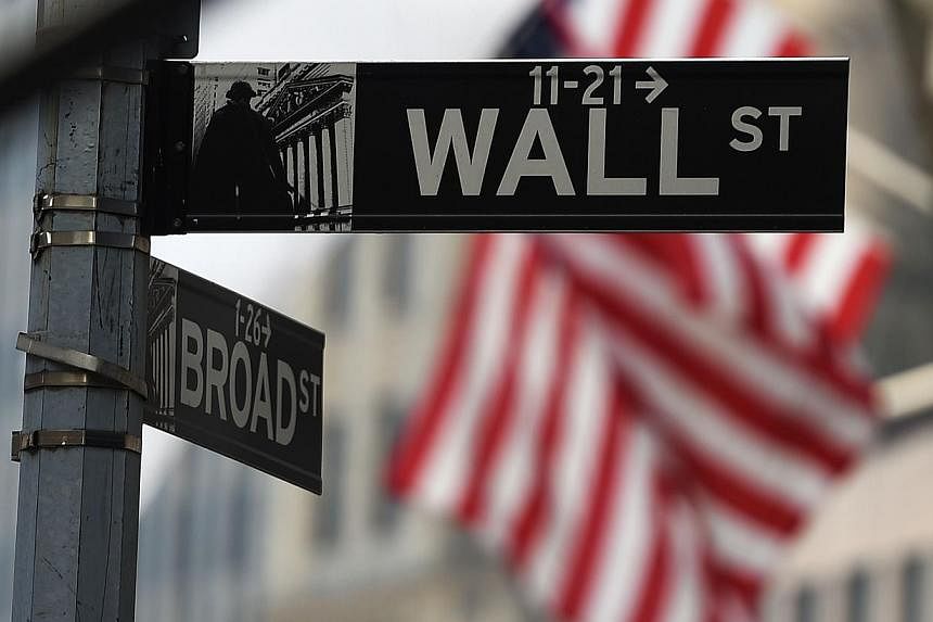 A Wall Street sign near the New York Stock Exchange (NYSE) building in New York. Wall Street stocks opened higher on Tuesday after stores reported their bigges ever "Cyber Monday" sales. -- PHOTO: AFP.