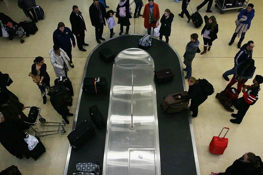 Travellers wait for their luggage after arriving at Ronald Reagan Washington National Airport on Nov 26, 2014. A doctor who cracked a joke about a bomb in his luggage partly forced the evacuation of Miami International airport on Oct 22, and earned a