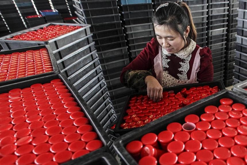 A woman working in a factory in Lianyungang, east China's Jiangsu province, on Nov &nbsp;17, 2014. A pair of manufacturing PMIs showed earlier in December that growth in factories in November slid to lows unseen in at least six months. -- PHOTO: AFP