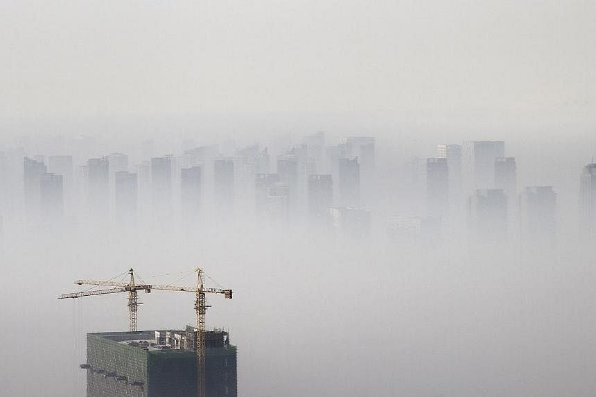 A building under construction is seen amid smog on a polluted day in Shenyang, Liaoning province, on Nov 21, 2014. -- PHOTO: REUTERS