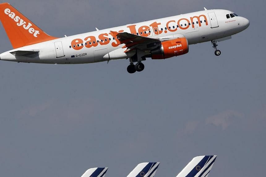 An easyJet aircraft takes-off past Air France plane tails at the Charles-de-Gaulle airport, near Paris, Sept 16, 2014. British finance minister George Osborne said he would scrap a tax charged on children flying out of the country, making it cheaper 