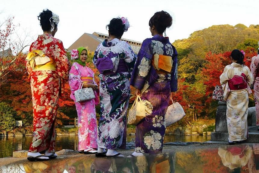 Tourists, dressed in traditional Japanese kimonos, stand in a park in Kyoto, western Japan on Nov 19, 2014.&nbsp;-- PHOTO: REUTERS