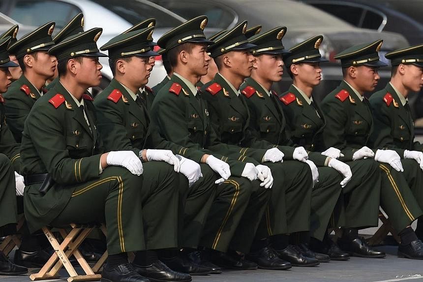 Chinese paramilitary policemen listen to a lecture outside their barracks in Beijing on Oct 29, 2014.&nbsp;China is to set up a database to trace corrupt officials who have fled overseas, the authorities have announced. -- PHOTO: AFP