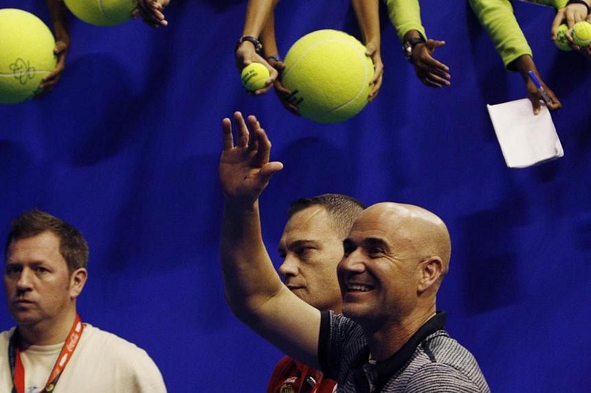 Singapore Slammers' Andre Agassi of the US waves to fans after the matches against Manila Mavericks at the International Premier Tennis League in Singapore Dec 2, 2014. American legend Agassi said the IPTL should take a lasting place in the sport des