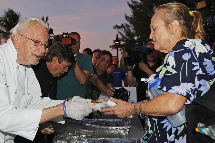 90-year-old activist Arnold Abbott (left) serves food in Fort Lauderdale on Nov 12, 2014. A judge on Tuesday suspended a local bylaw that limited how people could feed the homeless in the US city. -- PHOTO: REUTERS&nbsp;