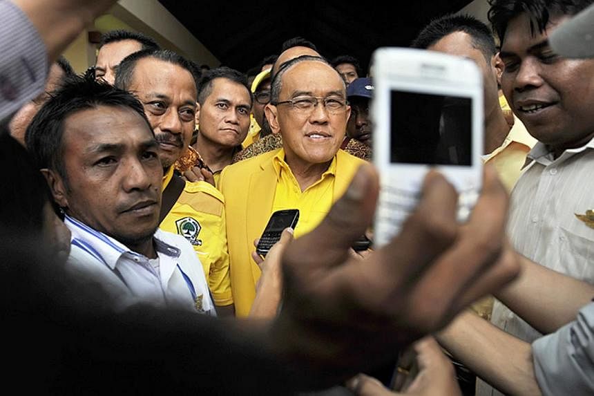 Aburizal Bakrie (centre), head of Indonesia's Golkar Party walks as he leaves the 9th Golkar Party National Conference in Nusa Dua, Bali resort island, Indonesia on Dec 1, 2014.&nbsp;Indonesia's second biggest party on Wednesday re-elected tycoon Abu
