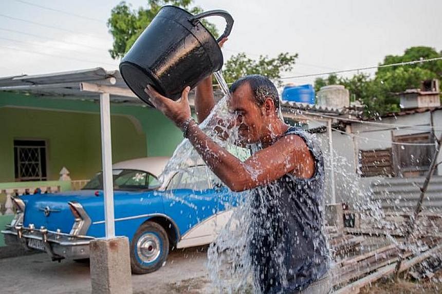 A Cuban man refreshes himself in a street of Havana, in this Aug 27, 2014, file photo.&nbsp;This year may end as the hottest on record, the UN's weather agency said Wednesday as it recounted a tale of rising seas, crippling droughts and floods since 