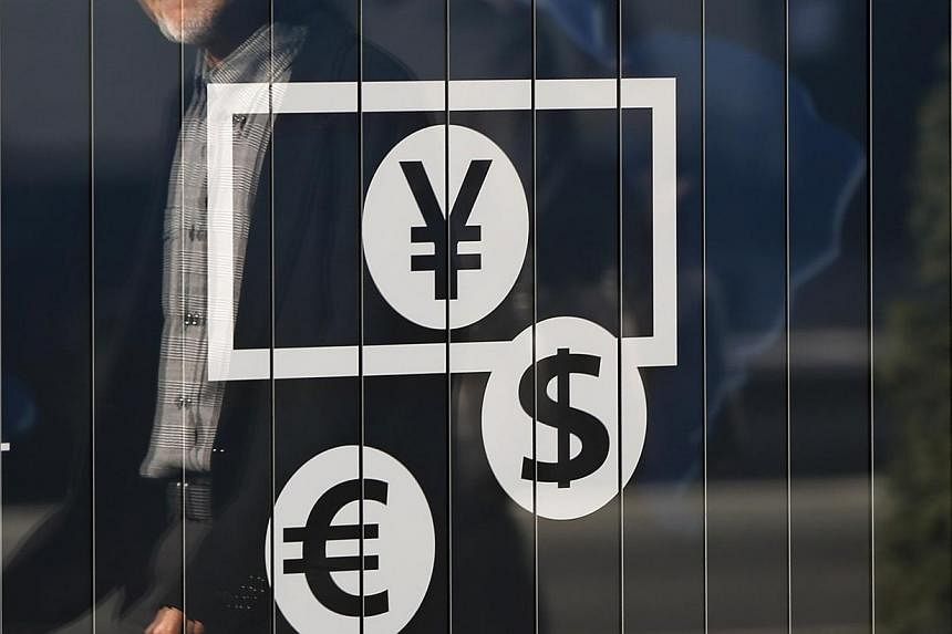 A currency signboard outside a bank in Tokyo on Nov 27, 2014. Most emerging Asian currencies skidded lower on Wednesday as the US dollar climbed to a seven-year high against the yen. -- PHOTO: REUTERS