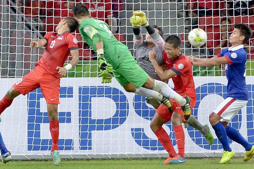 Lions goalkeeper Hassan Sunny (in green) attempting to score the equaliser in his team's AFF Suzuki Cup match against Malaysia at the National Stadium on Nov 29, 2014. -- ST PHOTO: LIM SIN THAI&nbsp;