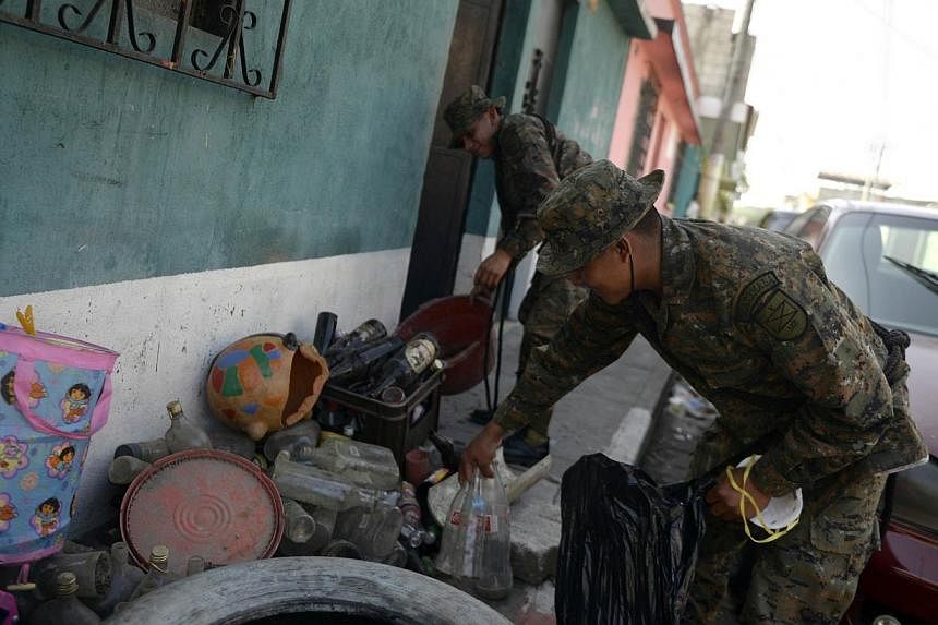Soldiers take part in a campaign to eliminate potential breeding sites of the Aedes mosquito which transmits dengue and chikungunya, in Amatitlan, 33km south of Guatemala City, on Nov 24, 2014. -- PHOTO: AFP&nbsp;