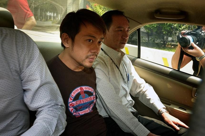 Yang Yin (centre) in a police car on Nov 5, 2014. The former China tour guide has been slapped with three additional charges under the Immigrations Act. -- PHOTO: ST FILE