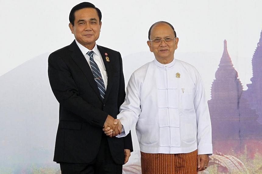 Thailand's Prime Minister Prayuth Chan-ocha shakes hands with Myanmar's President Thein Sein as he arrives for the East Asia Summit (EAS) plenary session during the ASEAN Summit in Naypyitaw on Nov 13, 2014.&nbsp;The two countries will sign a pact in