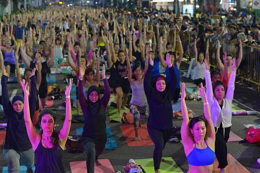 Almost 900 people practised yoga and turned Orchard Road into an open-air studio at the second Pedestrian Night in Orchard Road on Nov 1, 2014. -- PHOTO: ST FILE