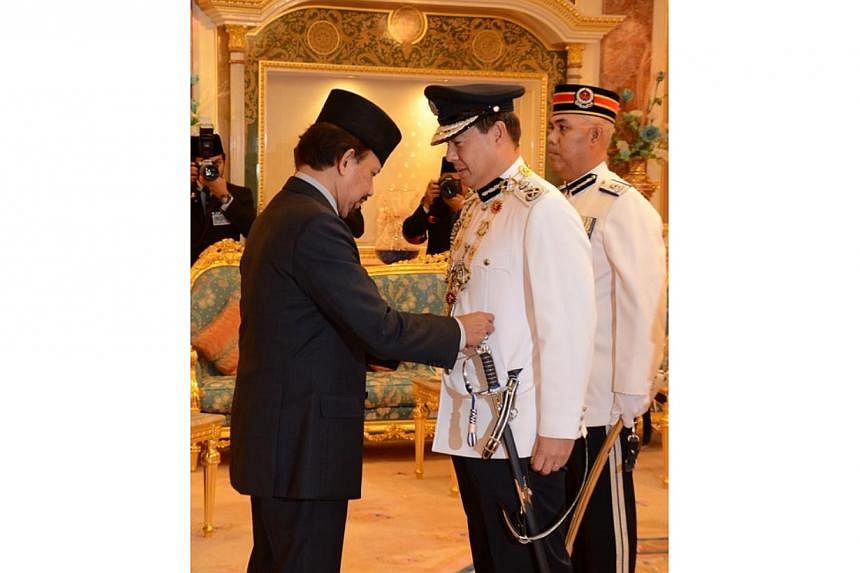 His Majesty Sultan Haji Hassanal Bolkiah Mu'izzaddin Waddaulah, Sultan and Yang Di-Pertuan of Brunei Darussalam (left) conferring the Darjah Pahlawan Negara Brunei Yang Amat Perkasa Darjah Pertama (PSPNB) or The Most Gallant Order of Pahlawan Negara 