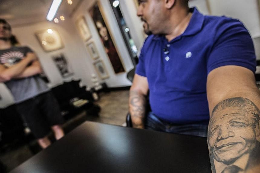 South African businessman Leesha Ramasamy, 42, shows off his tattoo representing Nelson Mandela at the fallen Heroes Tattoo studio on Nov 24, 2014 in Johannesburg, South Africa. Dec 5, 2014 will mark one year since Nelson Mandela, the 95-year-old for