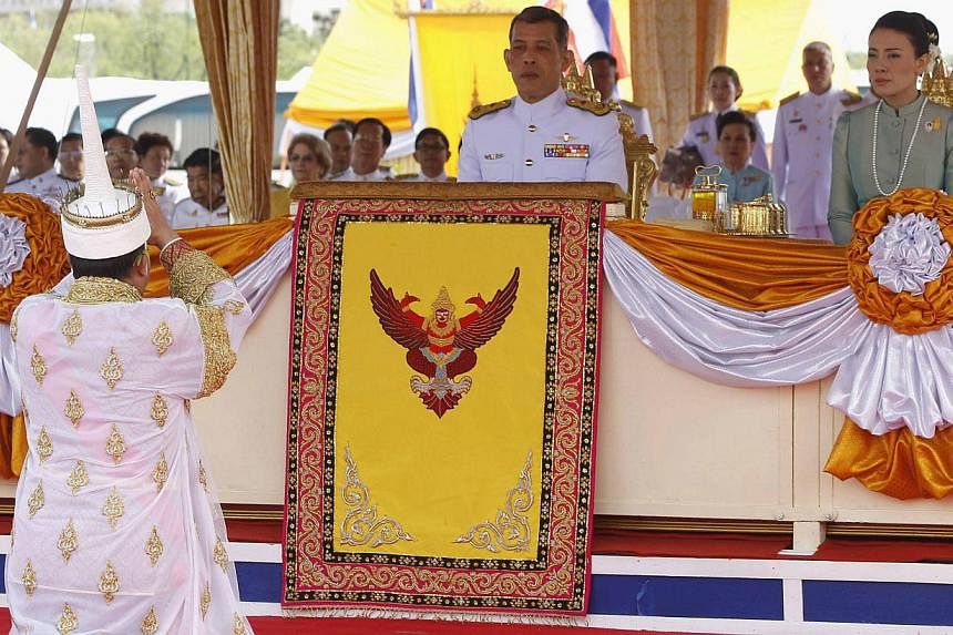 A Thai official dressed in a traditional costume greets Thailand's Crown Prince Maha Vajiralongkorn (left) and Royal Consort Princess Srirasmi during an annual royal ploughing ceremony in Bangkok on May 13, 2013. -- PHOTO: REUTERS