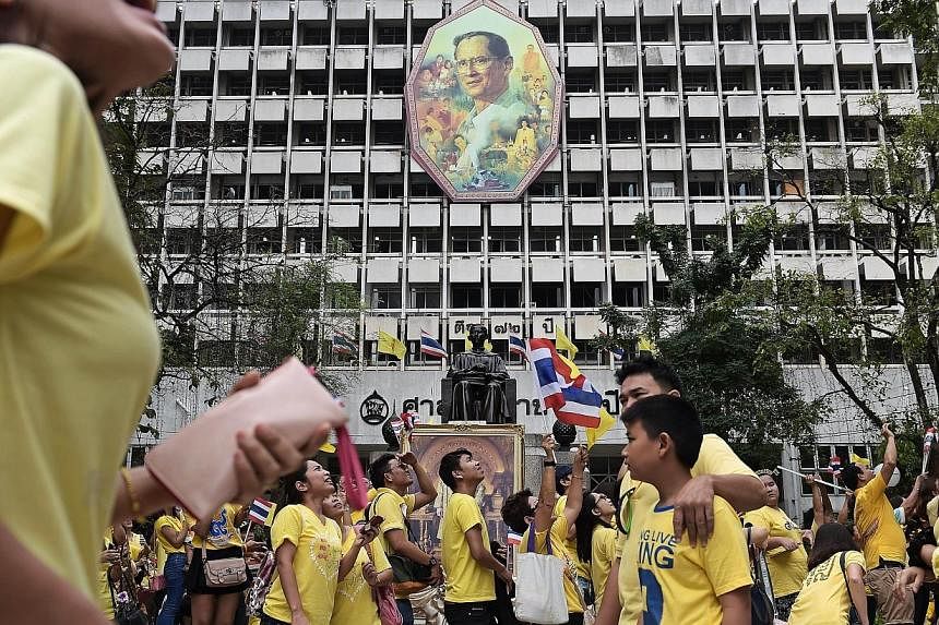 Thai well-wishers try and get a glimpse of King Bhumibol Adulyadej as they gather at Siriraj Hospital where the king has spent most of the last few months, on the occasion of his 87th birthday in Bangkok on Dec 5, 2014.&nbsp;Thailand's ailing King Bh