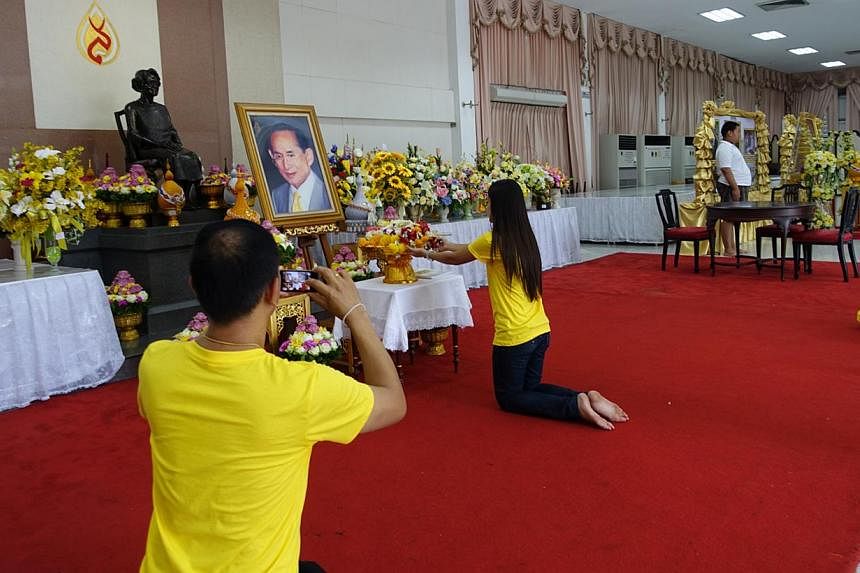 Well-wishers paying their respects before a giant portrait of the Thai monarch in a hall in Bangkok's Siriraj Hospital. King Bhumibol Adulyadej is convalescing in the hospital, where he lived between 2009 and last year. -- ST PHOTO: TAN HUI YEE