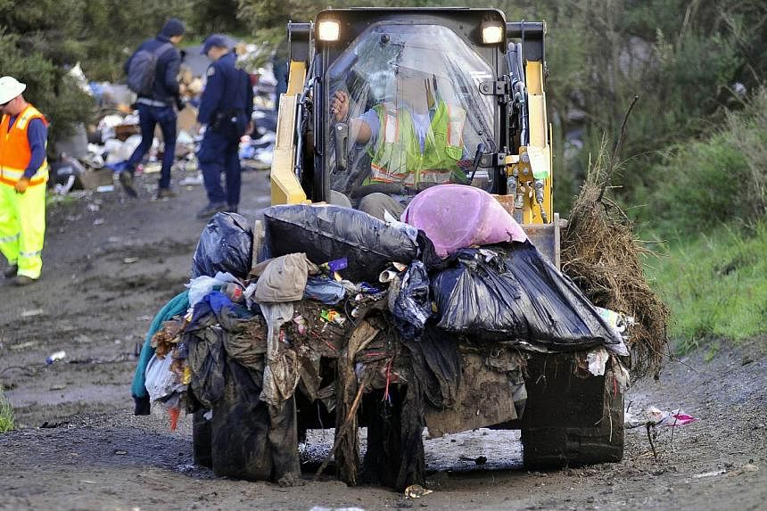 A bulldozer carries debris at a Silicon Valley homeless encampment known as The Jungle on Dec 4, 2014, in San Jose, California. Authorities began dismantling the homeless camp in the heart of California's affluent Silicon Valley. Municipal workers mo