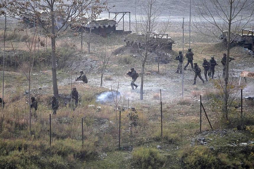 Indian army soldiers search for suspected militants as smoke rises from a bunker after a gunbattle in Mohra in Uri Dec 5, 2014.&nbsp;Militants hurling grenades stormed an army camp in Indian Kashmir on Friday, killing 11 troops and police in a day of
