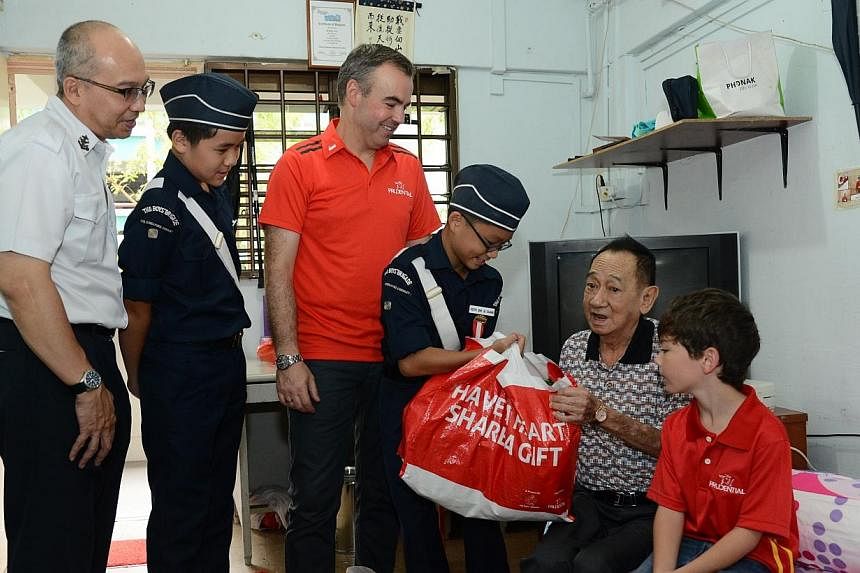 Mr Sim Soo Hee receives the food hampers from Mr Tan, Mr Sandham, his son Mikey and cadets from The Boys’ Brigade. -- PHOTO: BOYS' BRIGADE
