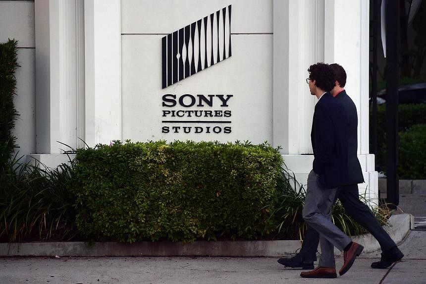 Pedestrians walk past an exterior wall to Sony Pictures Studios in Los Angeles, California on Dec 4, 2014. -- PHOTO: AFP
