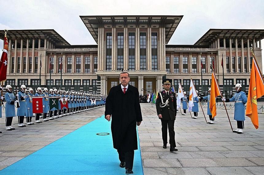 Turkish President Recep Tayyip Erdogan (middle) walks to welcome Russian President Vladimir Putin (unseen) during the official welcoming ceremony at Turkey's Presidential Palace in Ankara on Dec 01, 2014. -- PHOTO: AFP