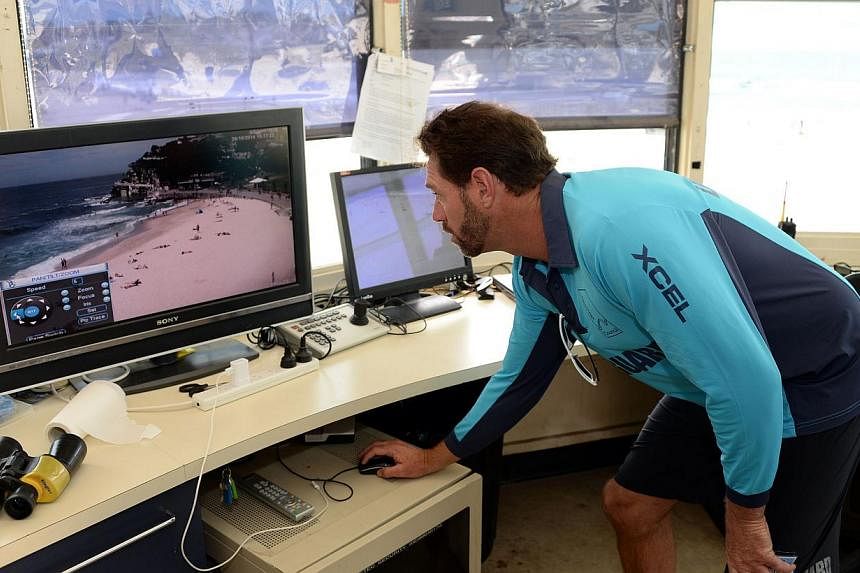 Australia's best known lifeguard Bruce "Hoppo" Hopkins monitoring different parts of beaches on close circuit camres at Bondi Beach in Sydney on Oct 28, 2014. -- PHOTO: AFP