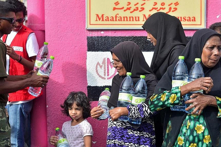 Maldives residents receive their supply of water distributed by Red Crescent and security personnel after a fire at a desalination plant affected water supplies in Male, on Dec 5, 2014.&nbsp;Maldivian President Abdulla Yameen cut short his trip to Ma