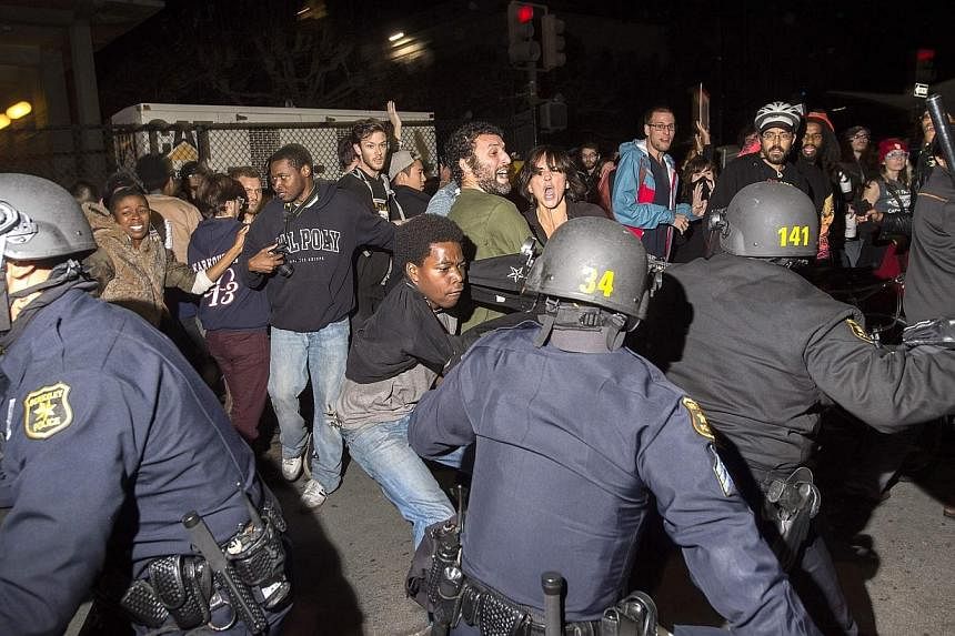 Police officers scuffle with protesters during a protest against police violence in Berkeley, California on Dec 6, 2014.&nbsp;Protests in California against a spate of recent killings of young African American suspects turned violent, as demonstrator