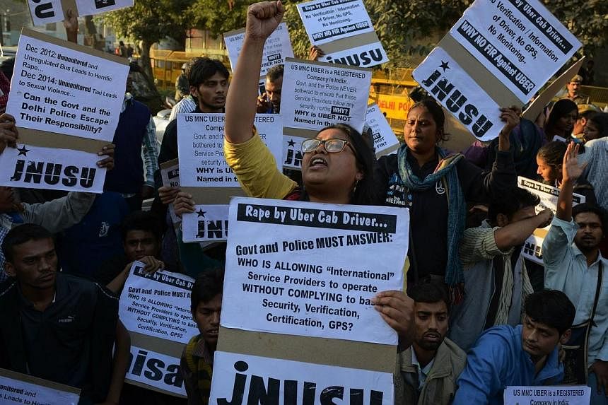 Indian residents hold placards and chant slogans as they take part in a protest against the alleged rape of a female passenger by a driver working for the Uber taxi company in New Delhi on Dec 7, 2014. -- PHOTO: AFP