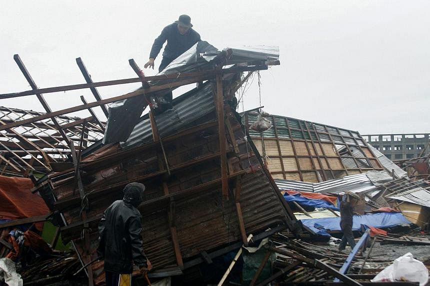 A man is seen on top of his damaged house in Tacloban, central Philippines on Dec 7, 2014.&nbsp;A powerful, slow-moving typhoon ripped through the central Philippines on Sunday, bringing howling winds that flattened houses and toppled trees and power