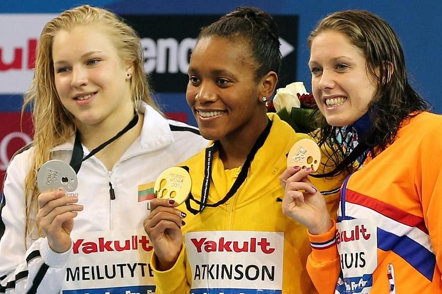 Alia Atkinson (centre) of Jamaica poses with her gold medal she won in the women's 100m breaststroke along with sliver medalist Ruta Meilutyte (right) of Lithuania and bronze medalist Moniek Nijhuis of the Netherlands during the 12th Fina World Swimm