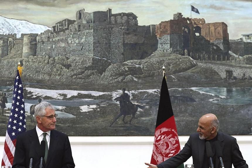 US Secretary of Defense Chuck Hagel (left) listens as Afghanistan's President Ashraf Ghani speaks during a joint news conference in Kabul Dec 6, 2014. The United States has handed to Pakistan three prisoners including a senior Taleban militant held i
