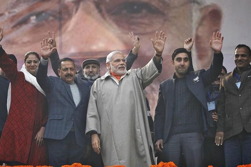 India's Prime Minister Narendra Modi (centre) waves to the crowd after he addressed an election campaign rally in Srinagar on Dec 8, 2014.&nbsp;Mr Modi promised to bring prosperity to Indian Kashmir and told people not to be intimidated against votin
