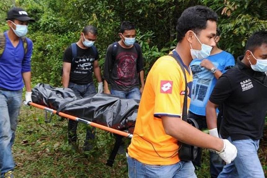Plainclothes police carrying remains believed to be that of a Myanmar national earlier in 2014 in Penang, Malaysia. In yet another case on Penang island, a man believed to be a foreigner was found with his throat slit and several stab wounds on his b