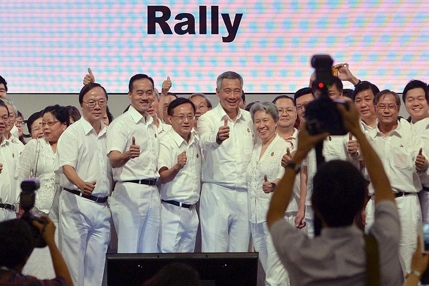 Prime Minister Lee Hsien Loong and his wife Ho Ching with former PAP Punggol East candidate Koh Poh Koon (fourth from left), Ang Mo Kio GRC MP Seng Han Thong (fifth from left) and PAP grassroots activists after the PAP rally yesterday. -- ST PHOTO: C