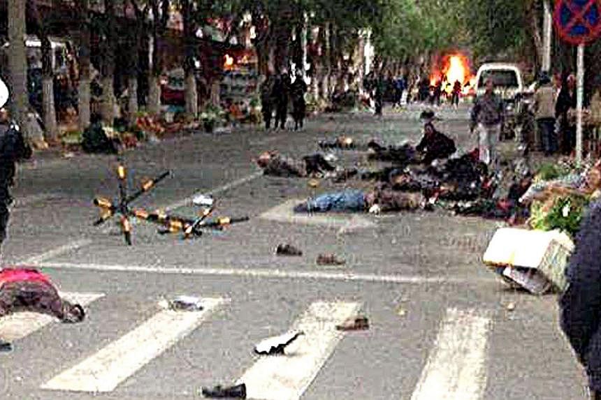 This file photo taken on May 22, 2014 shows victims of a bombing lying on a street near the site where attackers ploughed two vehicles into a market and threw explosives, killing at least 31 people, in Urumqi in north-west China's Xinjiang region. Ch