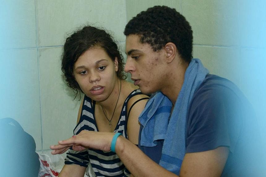 Heather Mack (left) of the US speaks with her boyfriend Tommy Schaefer (right) inside a holding cell at the procecutor's office in Denpasar on Indonesia's resort island of Bali on Dec 8, 2014. -- PHOTO: AFP