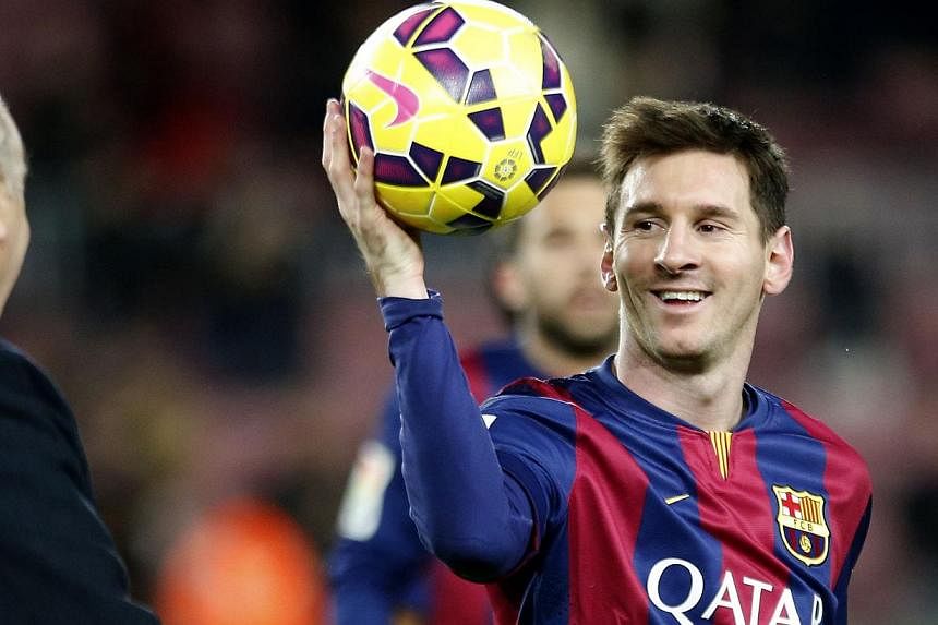Barcelona's Lionel Messi collects the ball after scoring his hat trick against Espanyol during their Spanish first division soccer match at Nou Camp stadium in Barcelona on Dec 7, 2014. -- PHOTO: REUTERS
