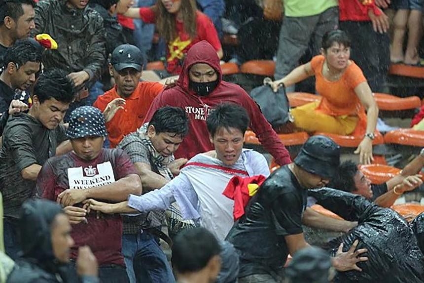 Malaysian fans clash with Vietnamese fans after Vietnam won 2-1 against Malaysia in their AFF Suzuki Cup semi-final first leg at Shah Alam stadium on Dec 7, 2014. -- PHOTO: ZING