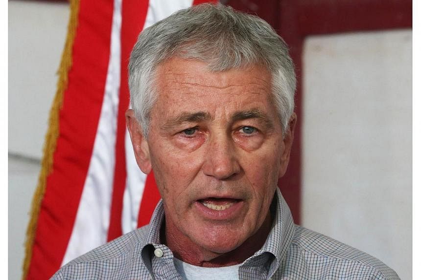 US Defence Secretary Chuck Hagel speaks to the media after visiting US troops at Camp Buehring in the north-west of Kuwait, roughly 65 miles from the Iraqi border, on Dec 8, 2014. -- PHOTO: AFP